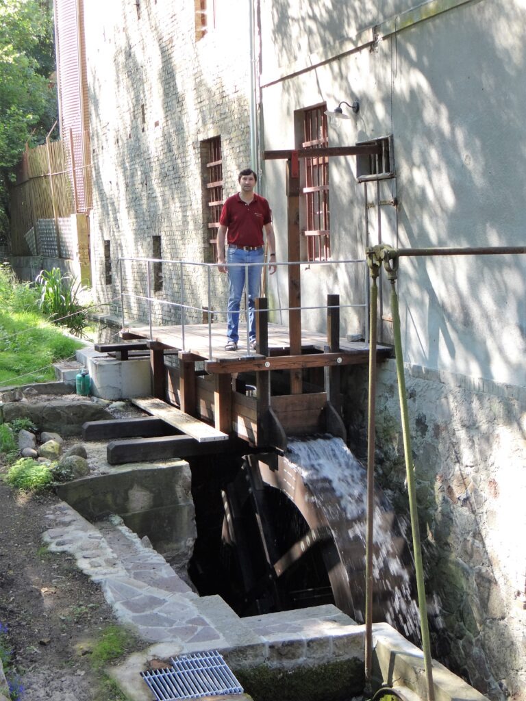 Historisches Mühlenrad mit fließendem Wasser